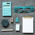 Mint calculator, eyeglasses, notebook and office supply on gray fabric background. flat lay, top view Royalty Free Stock Photo