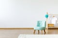 Mint chair, wooden hanger with a T-shirt on pompom and rug on an Royalty Free Stock Photo