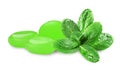 Mint hard candies and green leaves on white background