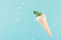 mint ice cream with mint leaves in waffle cone on a blue background with snow Royalty Free Stock Photo