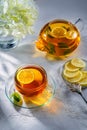 Mint and lemon tea on the table with a white tablecloth and a teapot in the background. Top view. Royalty Free Stock Photo