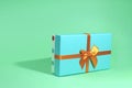 Mint shadow gift box with orange bow tied with ribbon on mint background for lettering Royalty Free Stock Photo