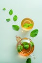 Mint tea. Flat lay, top view teapot and tea cup with mint leaves on green background Royalty Free Stock Photo