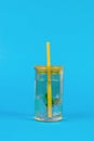 Mint with water in a large yellow glass on a blue background Royalty Free Stock Photo