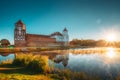 Mir, Belarus. Scenic View Of Castle Complex Mir And Lake In Misty Morning Fog During Summer Sunrise. Cultural Monument