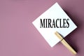 MIRACLES - word on white sheets of paper with clothespins on a coffee background Royalty Free Stock Photo