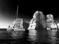 A miraculous black and white view and out-of-this-world view of yachts and the unique geology of Milos, a beautiful Greek island