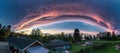 Miraculous panorama of sunset above scandinavian village with rose clouds - edge of cyclone. Arched dark sky with rose border to