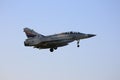 A Mirage 2000 flying in the sky on a hazy day and landing.