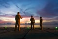 Unidentified people working oil and gas industrial enjoy the moment during sunset. Royalty Free Stock Photo