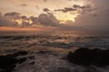 Mirissa, Sri Lanka. Sunset, hues over ocean horizon, sea waves gently caress rocky shore. Peaceful scenery at dusk