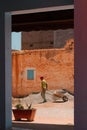 Mirleft, Morocco - male construction worker pulls wheelbarrow to a mound of gravel. Hard manual labor under the hot summer sun.