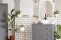 Mirror above grey cabinet with washbasin in bright bathroom inte