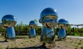 Mirror art object by sculptor Ken Kelleher Inner Child. Big baby heads with smiling faces in Public landscape city park Krasnodar