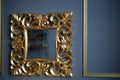 Mirror in a gold tracery frame on the background of the classic gray walls