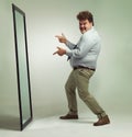 Mirror, portrait and man with smile pointing, double chin and happiness for reflection in studio. Overweight, plus size Royalty Free Stock Photo