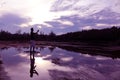 Mirror of purple sky reflection to the water with shadow of photographer. Royalty Free Stock Photo
