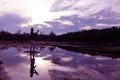 Mirror of purple sky reflection to the water with shadow of photographer.