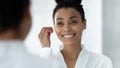 Mirror reflection African American woman cleaning ears, using cotton bud Royalty Free Stock Photo