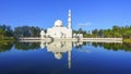 Mirror reflection of beautiful white floating mosque in a lake d