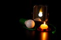 Mirror with reflection of the burning lamp, green non burning bulb with rope and burning yellow candle in the red candlestick are Royalty Free Stock Photo