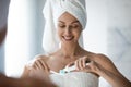 Smiling woman with towel on head doing morning toothcare routine. Royalty Free Stock Photo