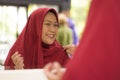 Mirror reflection of young happy and beautiful Muslim woman in traditional hijab adjusting red head scarf in beauty and fashion Royalty Free Stock Photo