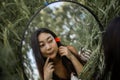 Mirror Reflection Of Young Pretty Asian Woman Holding Red Poppy Flower In Green Field Royalty Free Stock Photo