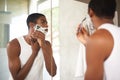 Mirror, shaving or grooming and black man in bathroom of home with razor for morning hair removal. Face, skincare and Royalty Free Stock Photo