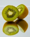 On the mirror is a sliced ripe kiwi. on a white background.