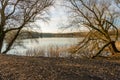 Mirror smooth lake framed by two bare trees