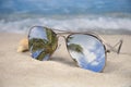 Mirror sunglasses in tropical beach sand Royalty Free Stock Photo