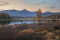 Mirror Surface Lake Autumn Landscape With Mountain Range On Background With Light Pink Sky