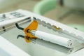 On the mirror surface lies a device for filling and drying teeth - a dental polymerization lamp Royalty Free Stock Photo