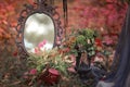 Mirror and table with decorations in the forest with fallen leaves Royalty Free Stock Photo