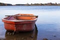 Mirror view of a calm lake with an old rowing boat on a sunny day.