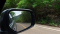 Mirror view of gray car travel on the asphalt road. Royalty Free Stock Photo