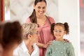 Mirror, vision and girl trying on glasses in an optical store with her mother and senior optometrist. Happy, smile and