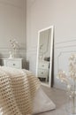 Mirror in white frame on grey wall of stylish scandinavian bedroom interior