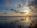 Mirrored Balinese beach at sunset with reflection of clouds in the wet sand Royalty Free Stock Photo