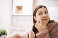 Mirrored image of woman applying face cream