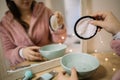 Mirrored image of woman holding cotton pad above a bowl