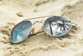 Mirrored sunglasses close up on the beach sand with palm trees reflection Royalty Free Stock Photo