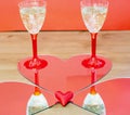 Mirroring of two champagne glasses and little heart Royalty Free Stock Photo