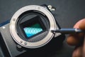 Mirrorless camera sensor repair, screwdriwer over lens mount. Royalty Free Stock Photo