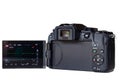 Mirrorless high-tech digital camera from rear with viewscreen out and engergised Royalty Free Stock Photo