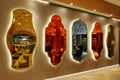 Mirrors of different shapes and colors hanging on a wall in a row, design