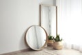 Mirrors and potted plant near window in room Royalty Free Stock Photo