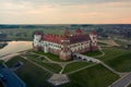 Mirsky Castle and its reflection in the lake in summer. Sunset in cloudy weather with rain clouds. Aerial view from a drone Royalty Free Stock Photo