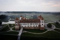 Mirsky Castle and its reflection in the lake in summer. Sunset in cloudy weather with rain clouds. Aerial view from a drone Royalty Free Stock Photo